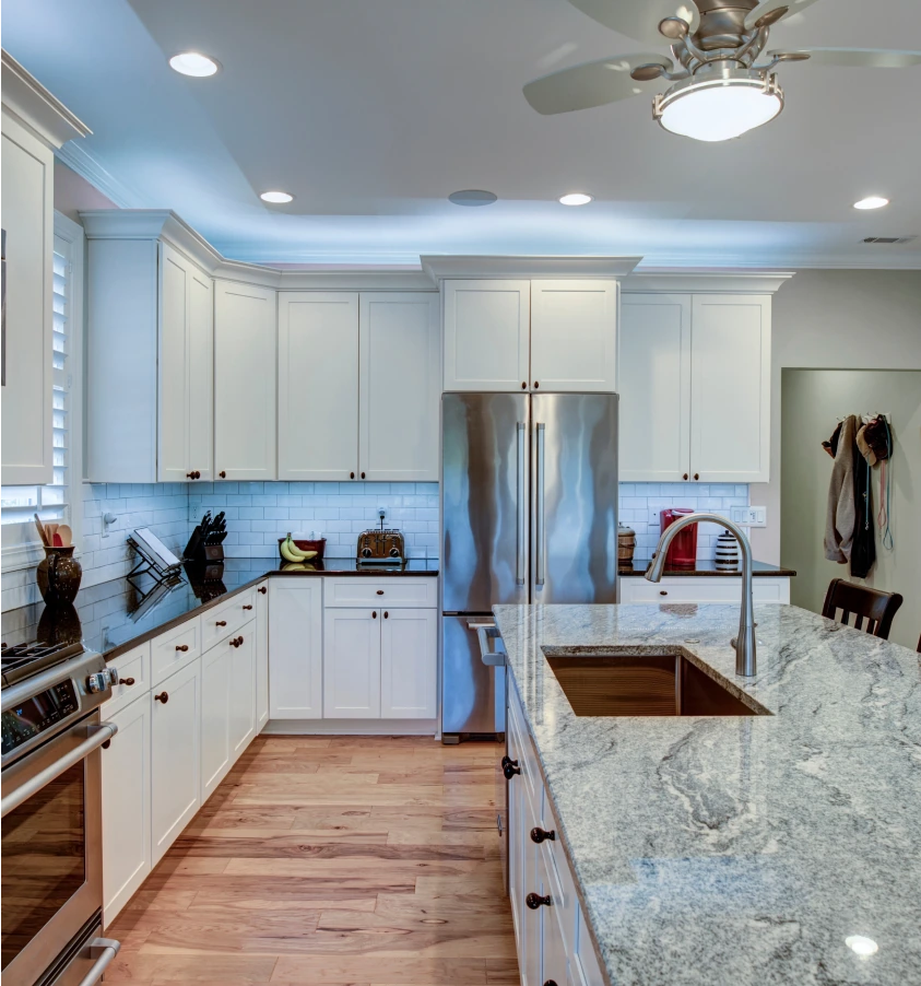 White and brown kitchen with grey granite countertops by Granite Gomez.