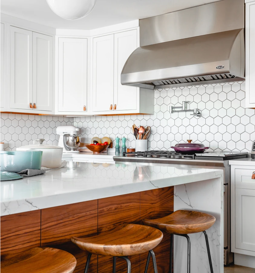 Modern kitchen with white, black, and orange tones and a granite countertop.